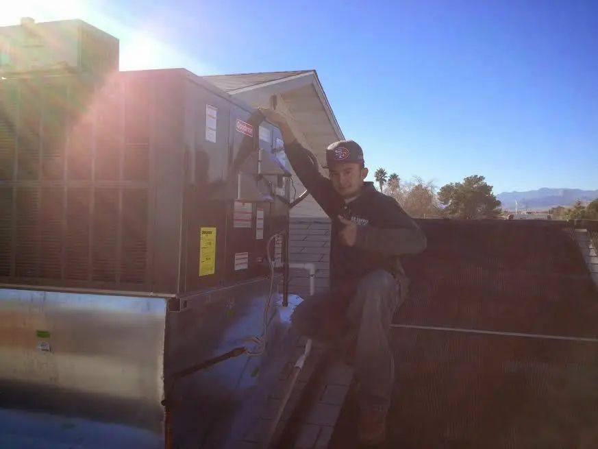 HVAC technician performing AC Tune-Up on a rooftop unit in Manchester-by-the-Sea